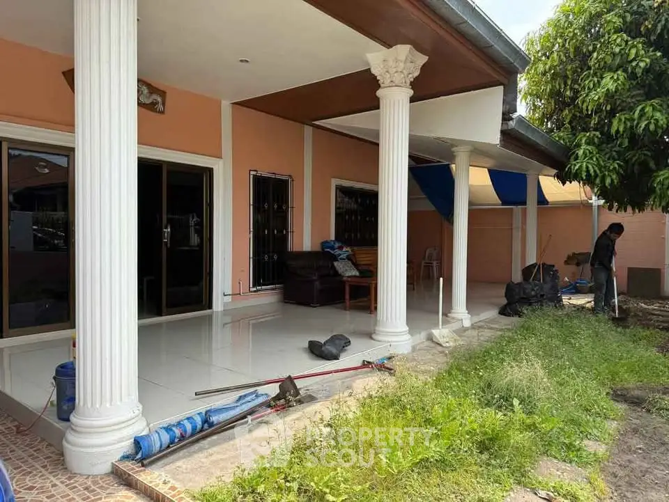 Charming home exterior with elegant columns and spacious patio area, perfect for outdoor relaxation.