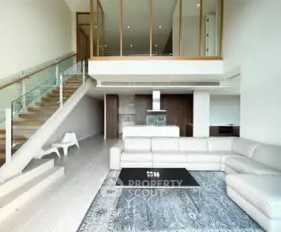 Luxurious modern living room with high ceilings and elegant staircase