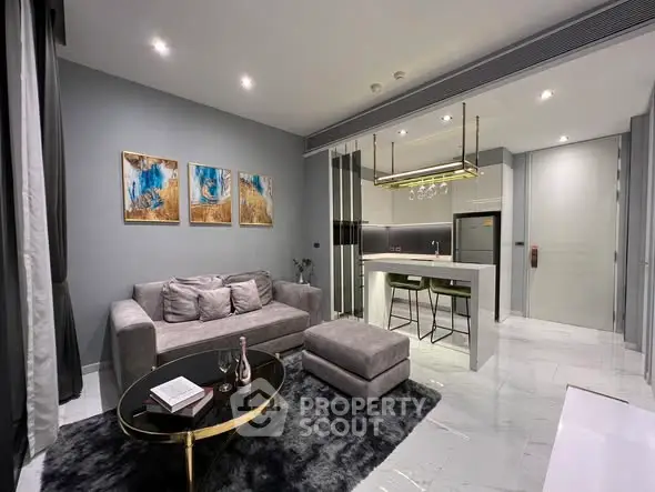 Modern open-plan living room with stylish decor and sleek kitchen area.