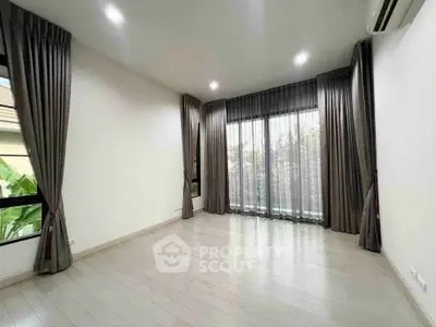 Spacious empty room with large windows and elegant curtains, perfect for customization.