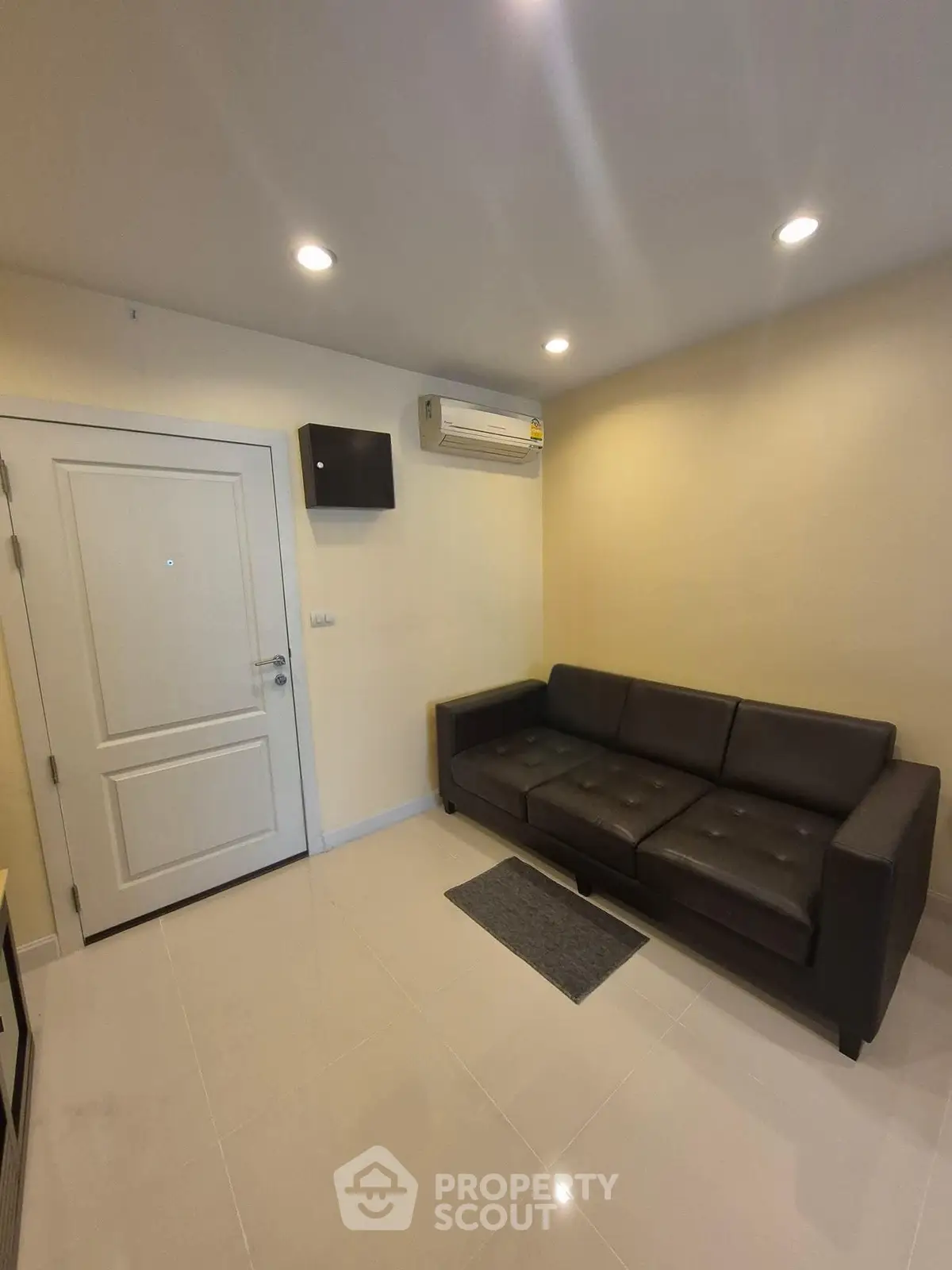 Modern living room with sleek brown sofa and air conditioning, perfect for cozy relaxation.