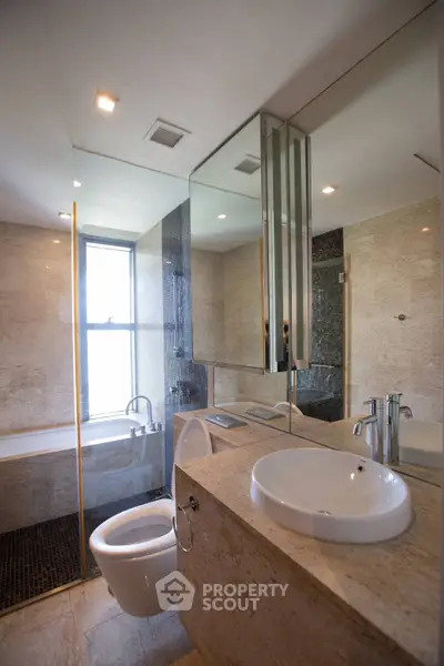 Luxurious modern bathroom with elegant marble finishes and large mirror