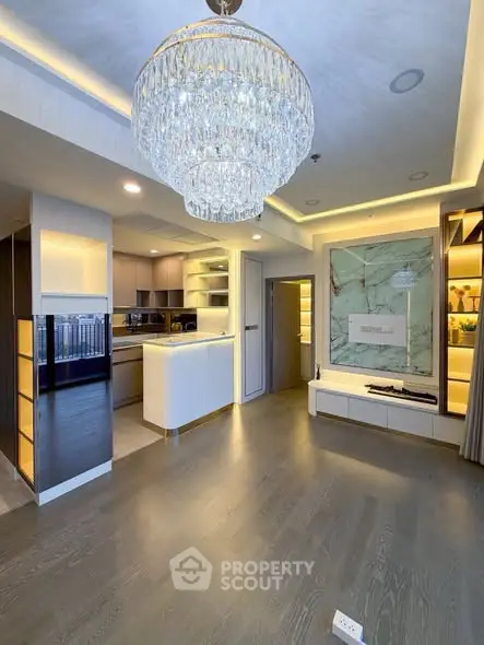 Luxurious modern living room with elegant chandelier and open kitchen layout