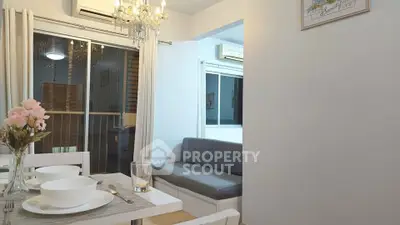 Cozy dining and living area with elegant chandelier and modern decor