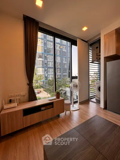 Modern living room with large windows and balcony view in urban apartment