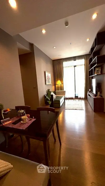 Modern living room with elegant decor and ample natural light, featuring a cozy dining area and stylish shelving.