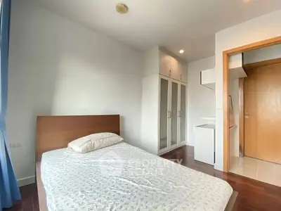 Bright and cozy bedroom with wooden flooring and built-in wardrobe