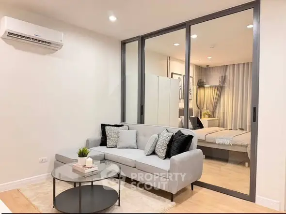 Modern living room with glass partition and cozy decor in stylish apartment.