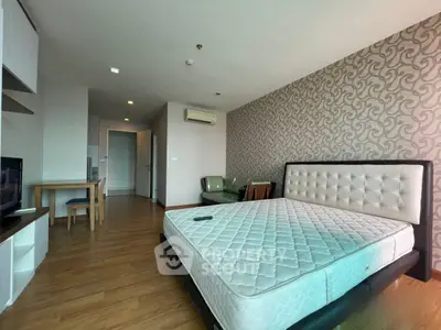 Spacious bedroom with modern decor and wooden flooring in a stylish apartment.
