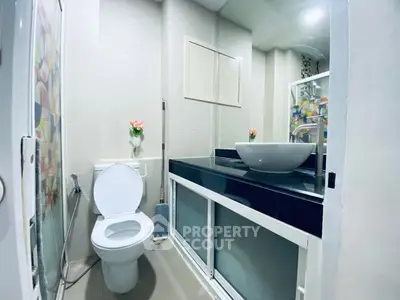 Modern bathroom with sleek black countertop and elegant vessel sink