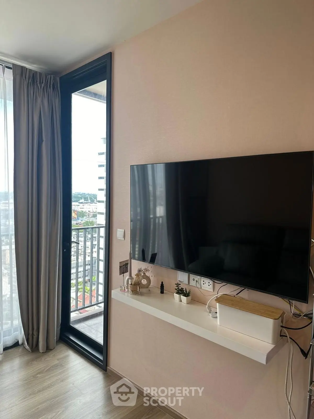 Modern living room with wall-mounted TV and balcony view