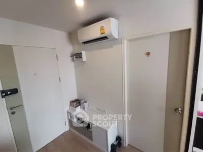 Modern apartment entryway with air conditioning and sleek storage solutions.