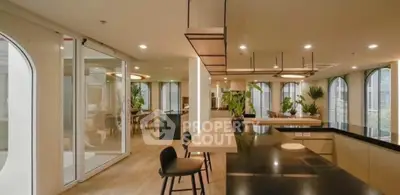 Luxurious modern kitchen with sleek black countertops and open layout, featuring elegant lighting and stylish decor.