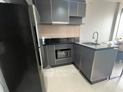 Modern kitchen with sleek black cabinetry and built-in appliances in a stylish apartment.