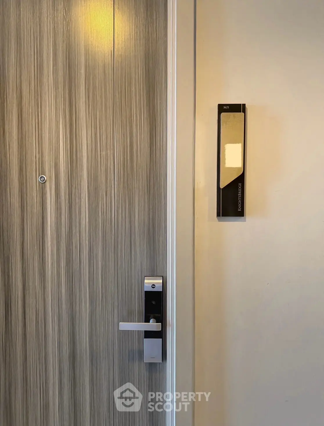 Modern apartment entrance with sleek door and electronic lock system.