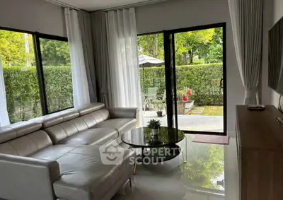 Modern living room with sleek leather sofa and garden view