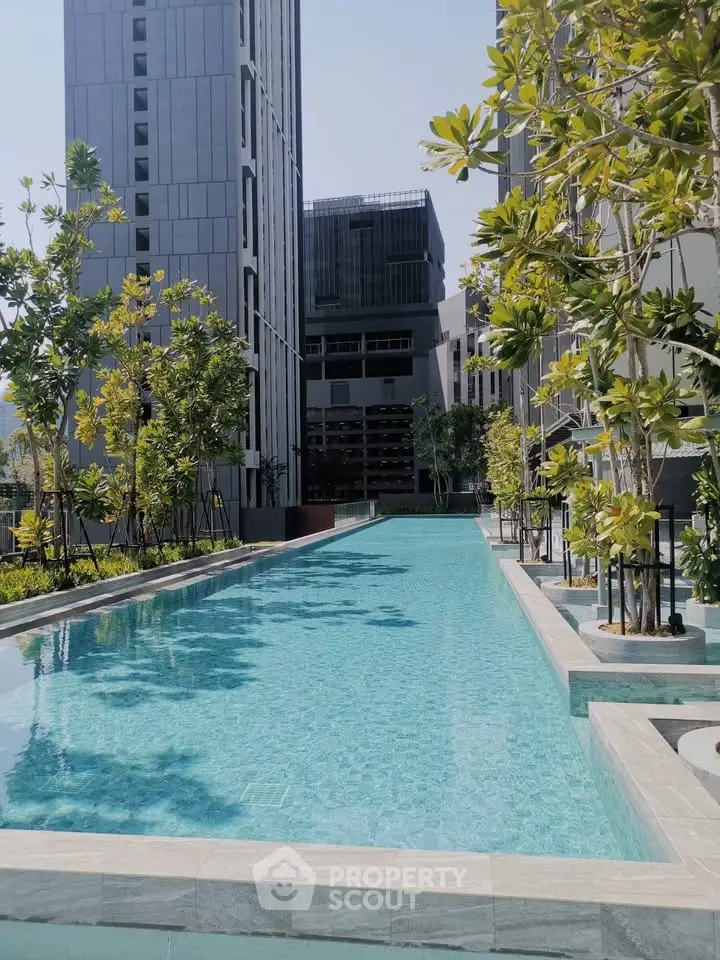 Luxurious modern apartment complex with stunning outdoor pool and lush greenery.