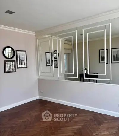 Elegant room with parquet flooring and mirrored wall, perfect for modern living.