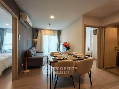 Modern apartment interior with cozy living room and dining area, featuring elegant decor and natural light.