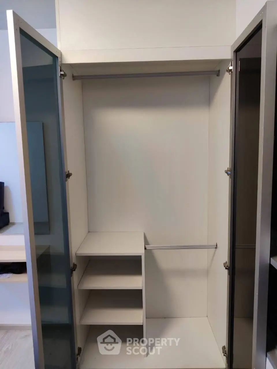 Spacious modern wardrobe with open doors and shelving in a stylish apartment.