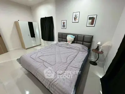 Modern bedroom with stylish decor and cozy bedding in a contemporary apartment.