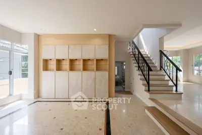 Spacious modern living room with elegant staircase and natural light