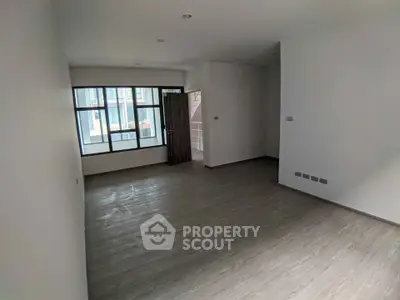 Spacious empty living room with large windows and wooden flooring