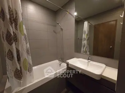 Modern bathroom with bathtub and sleek sink in contemporary apartment.