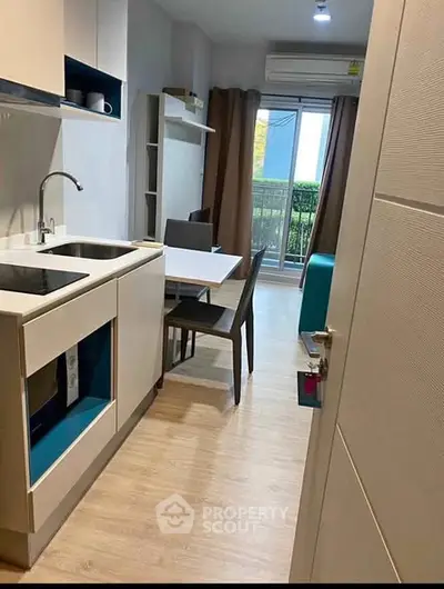 Modern kitchen with sleek design and balcony view, perfect for urban living.