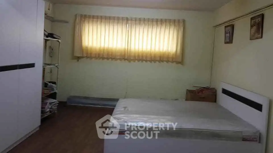 Spacious bedroom with natural light and modern furnishings, ideal for comfortable living.