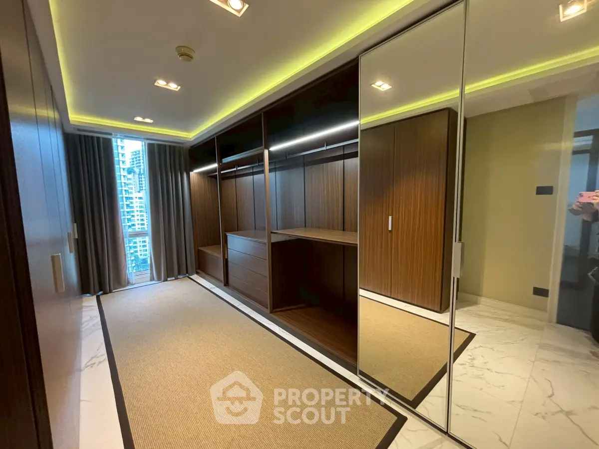 Luxurious walk-in closet with mirrored doors and elegant lighting