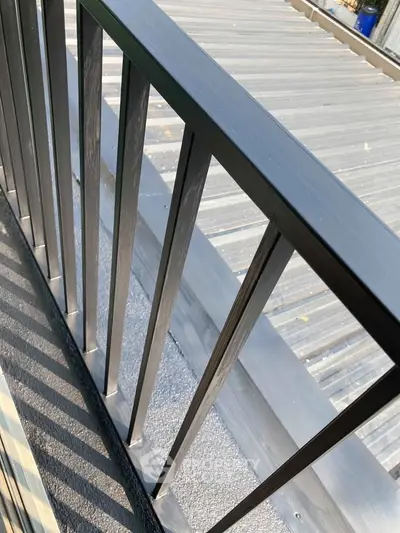 Modern balcony railing with sleek design and metal roof view.