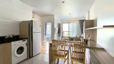 Modern open-layout kitchen with dining area and washing machine in a bright apartment.
