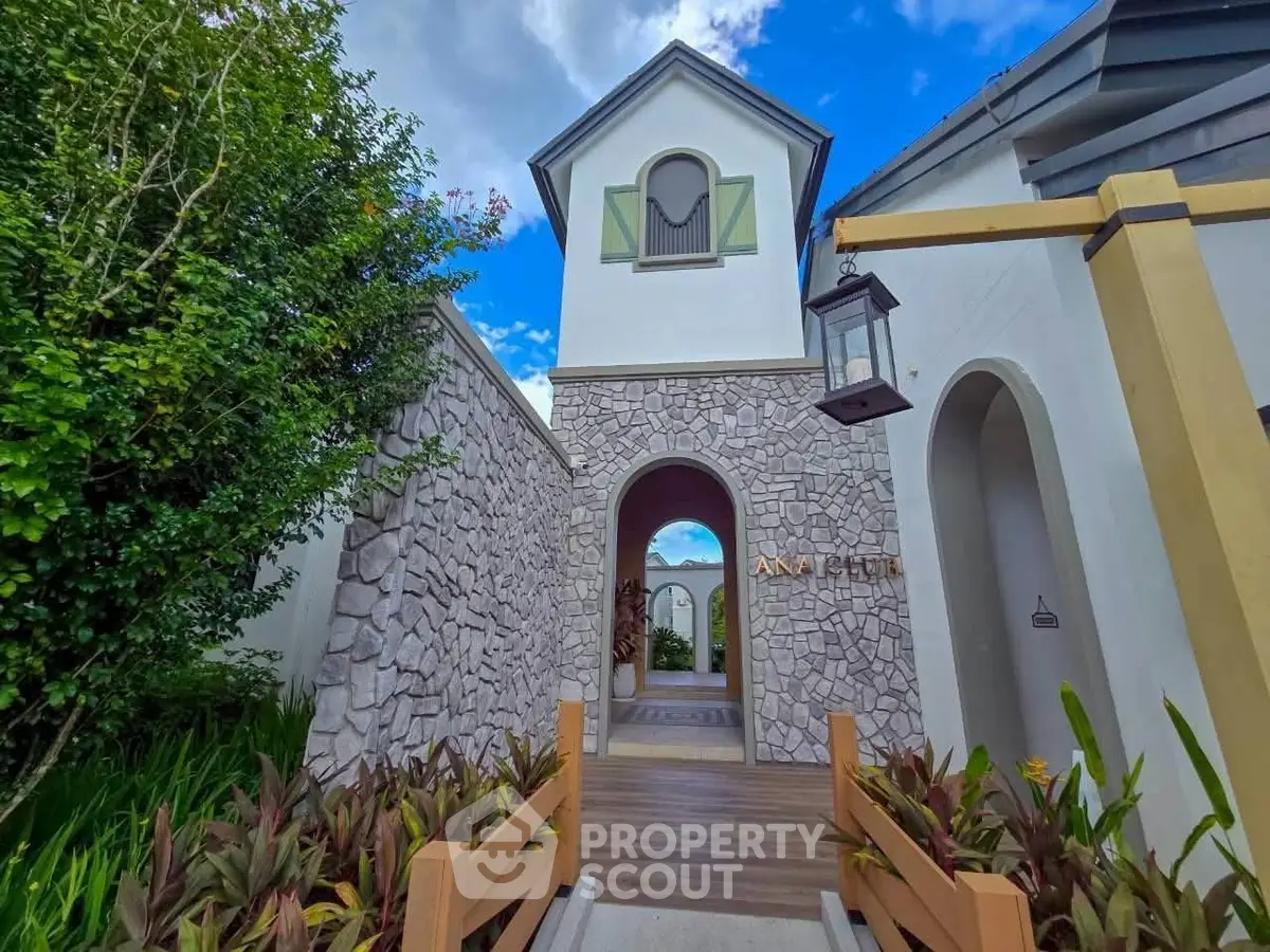 Charming stone facade entrance with lush greenery and elegant architectural details.