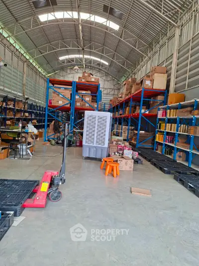 Spacious warehouse with high ceilings and organized shelving units, ideal for storage and logistics operations.