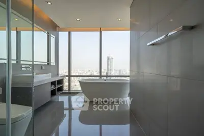 Luxurious bathroom with city view and freestanding bathtub in high-rise apartment.
