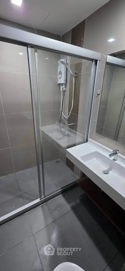 Modern bathroom with glass shower enclosure and sleek sink design