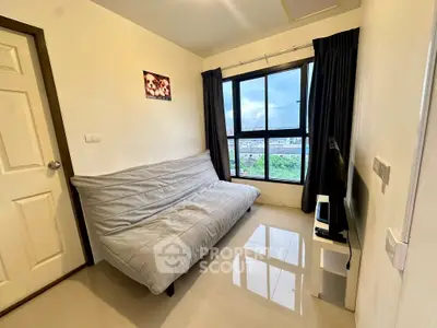 Cozy living room with a modern sofa and large window offering a scenic view.