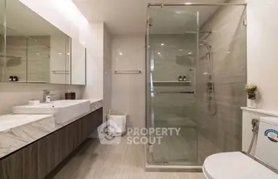 Modern bathroom with glass shower, sleek vanity, and elegant fixtures