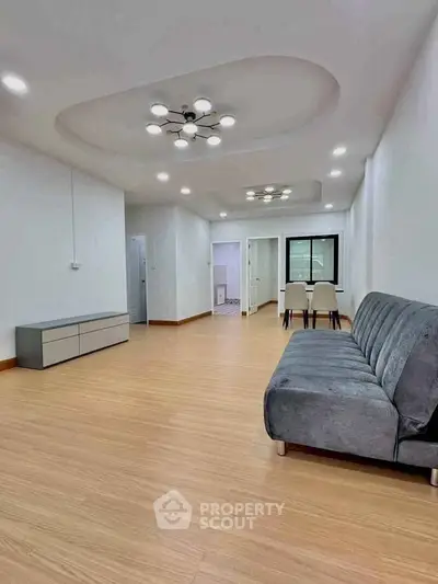 Spacious modern living room with elegant lighting and sleek furniture.