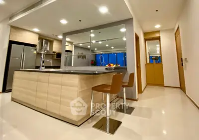 Modern kitchen with sleek island and bar stools in open layout apartment