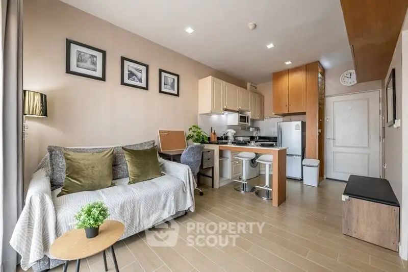 Modern living room with cozy sofa and stylish kitchen in open layout apartment.