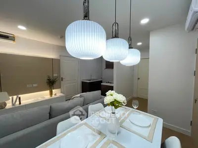 Modern open-plan living and dining area with stylish lighting and elegant decor.