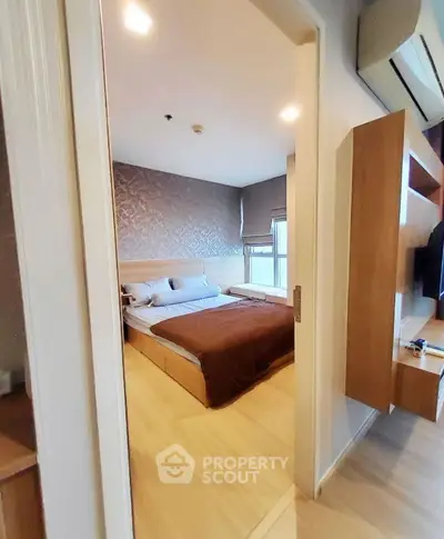 Modern bedroom with stylish decor and natural light, featuring a cozy bed and sleek furnishings.