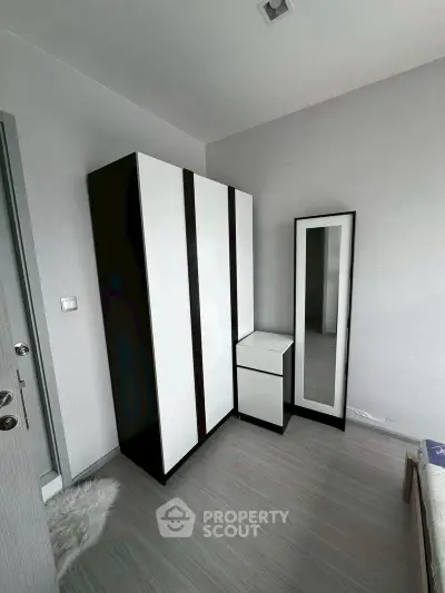 Modern bedroom with sleek wardrobe and full-length mirror, perfect for stylish living.