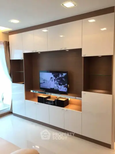 Modern living room with sleek built-in entertainment center and natural light.