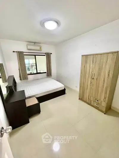 Spacious bedroom with modern furnishings and natural light