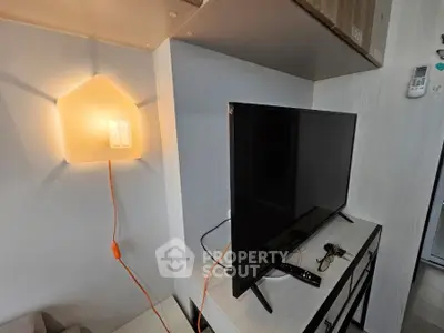 Modern living room with stylish wall lamp and flat-screen TV, perfect for cozy evenings.