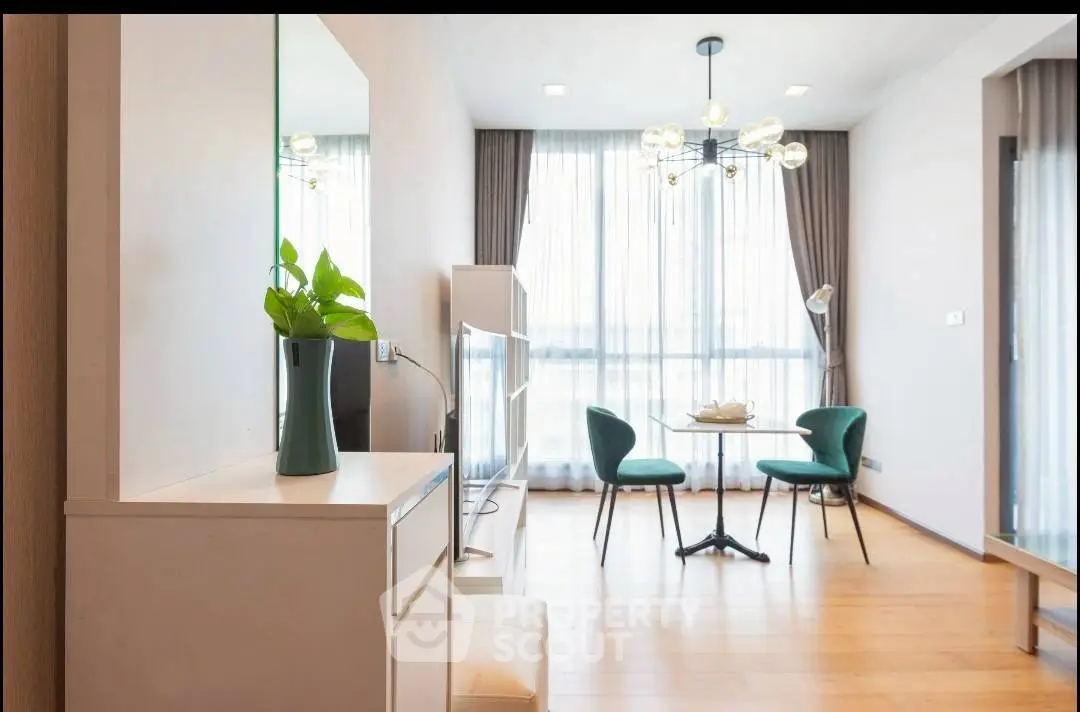 Modern living room with elegant decor and natural light, featuring a stylish dining area.