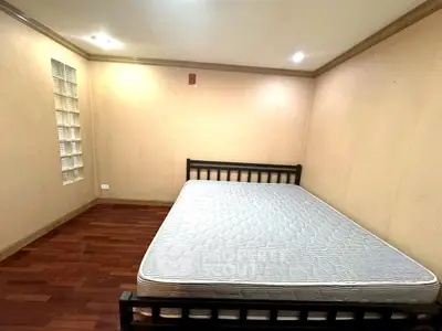 Spacious bedroom with wooden flooring and minimalist design